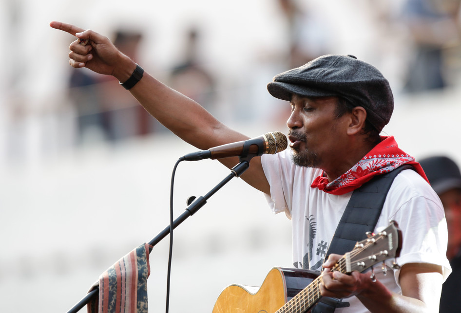 Glenn Fredly mengenakan kaus putih dan scarf merah, sedang tampil di salah satu acara musik.
